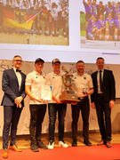 Die jungen Männer vom Tauziehclub Allgäu haben ihren riesigen Pokal mit auf die Bühne gebracht. 