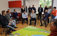 Die Kreisrätinnen und Kreisräte sitzen im Stuhlkreis im Lehr-Kindergarten der Fachakademie für Sozialpädagogik. 