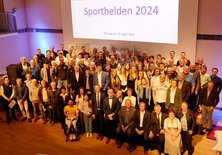 Alle Sportlerinnen und Sportler haben sich auf der Bühne versammelt fürs Gruppenfoto. 