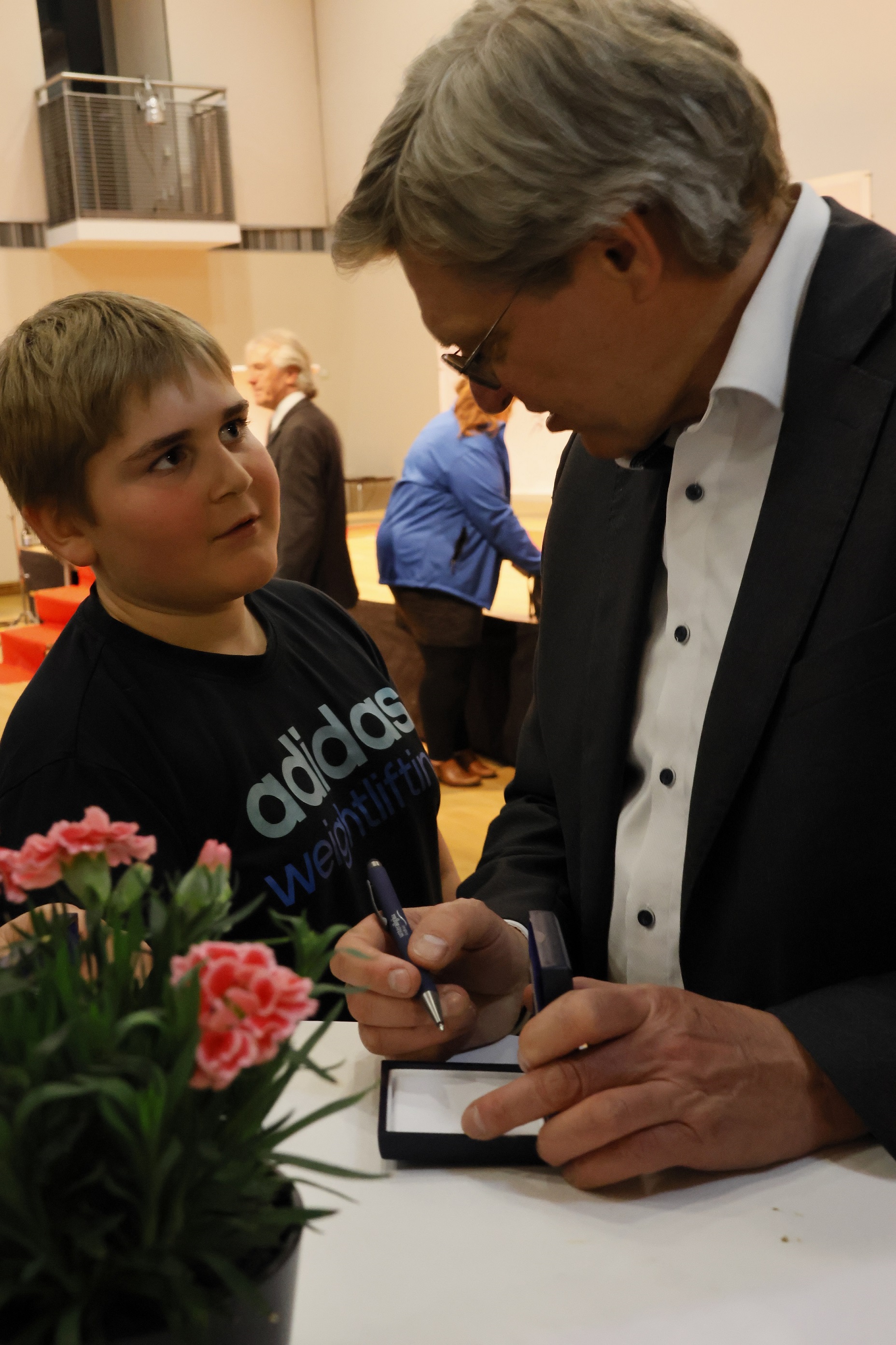 Ein Junge lässt von Überraschungsgast Thomas Burger sein Medaillen-Etui signieren. 